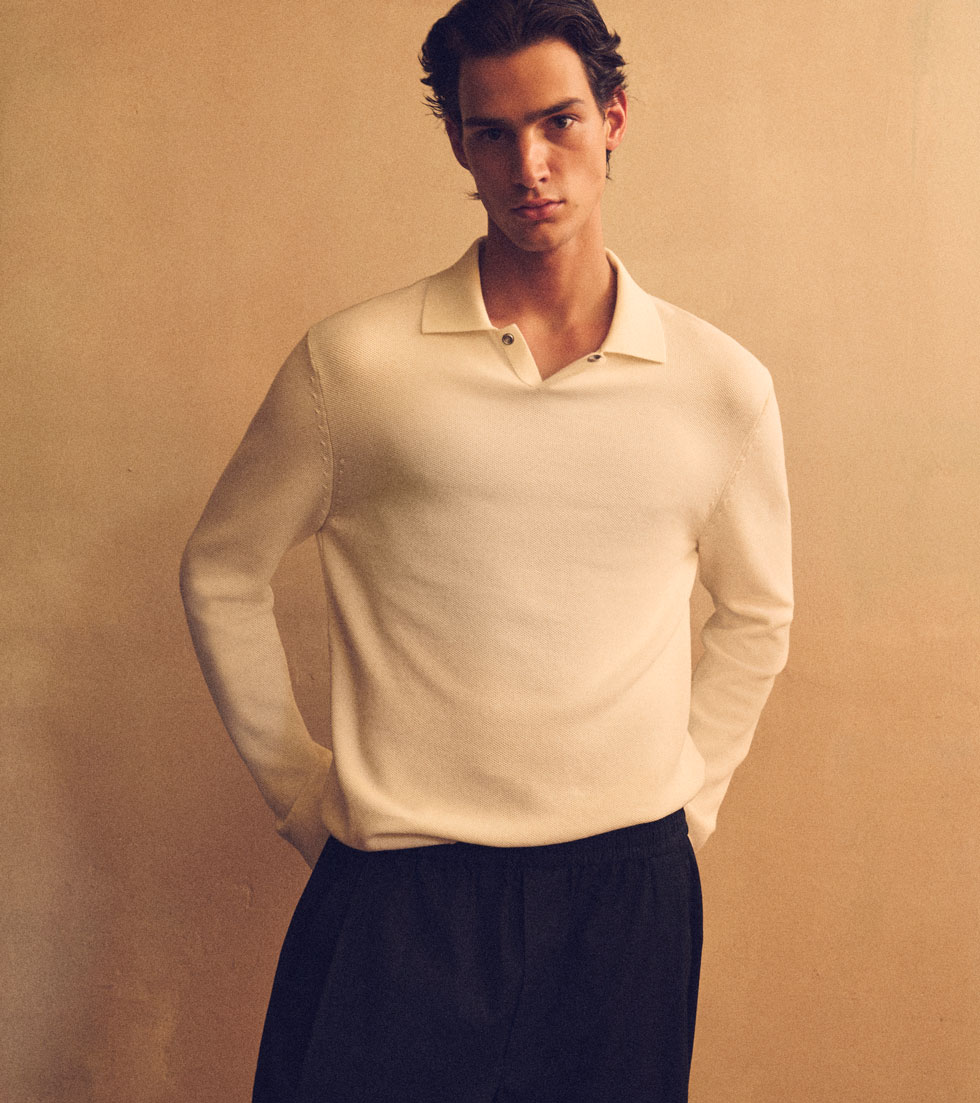 COS Pre-Fall: model in a cream knit polo and black trousers.