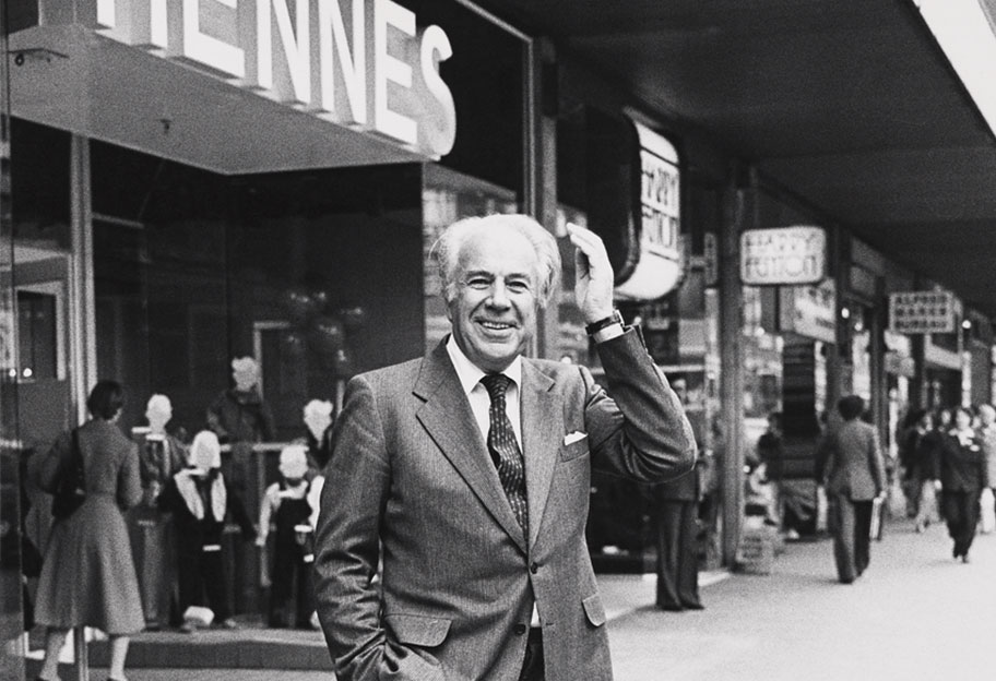 Old picture of Erling Persson in front of the entrance of a Hennes store